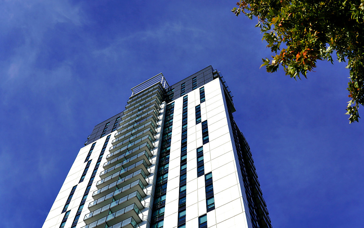 High-rise apartment tower against a blue sky