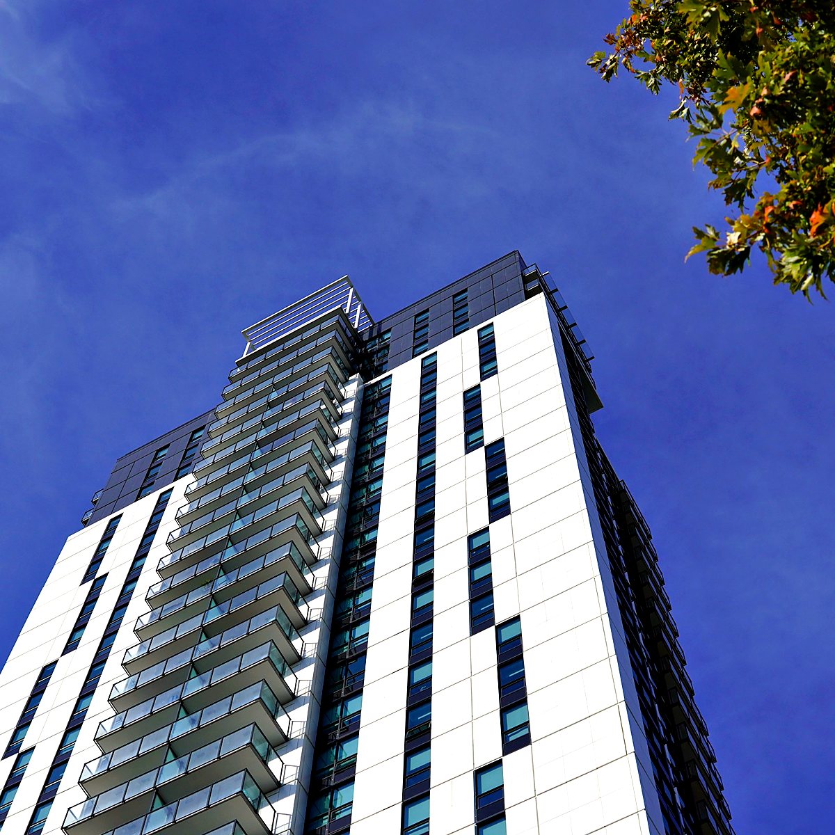 High-rise apartment tower against a blue sky