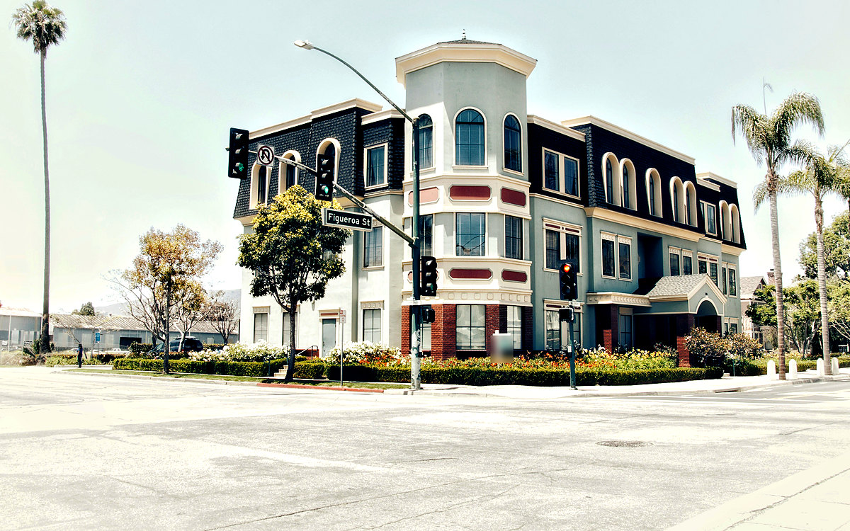 Three-story corner office building with palm trees, California