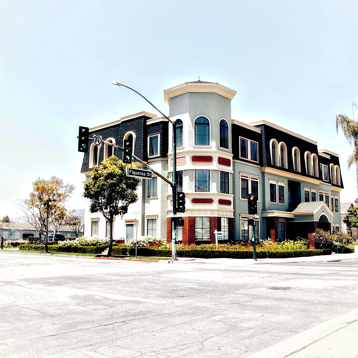 Three-story corner office building with palm trees, California